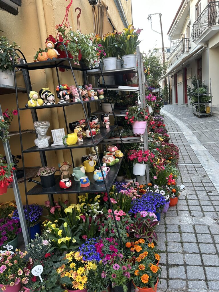 Floristería colorida en una calle peatonal de Egina, Grecia